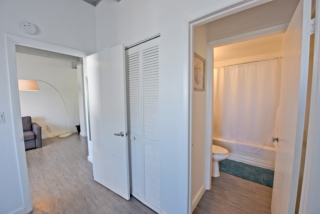 a bedroom with a door to a bathroom and a closet