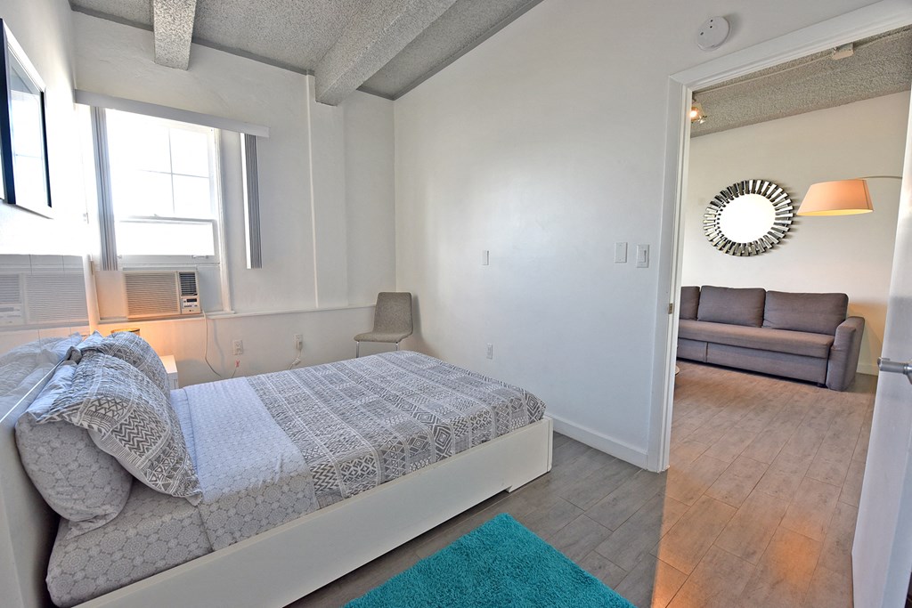 a bedroom with a bed and a living room with a couch