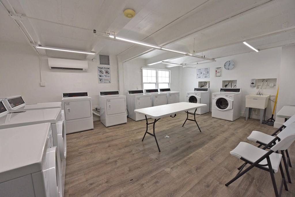 an empty laundry room with washing machines and a table