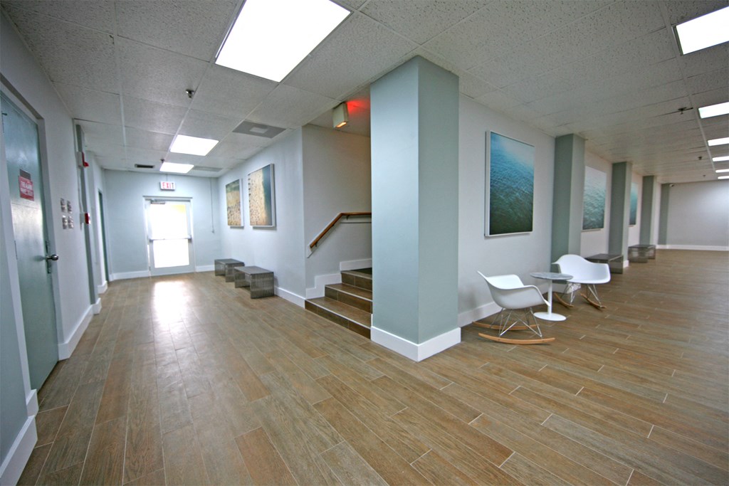 a hallway with a wood floor and blue walls and stairs