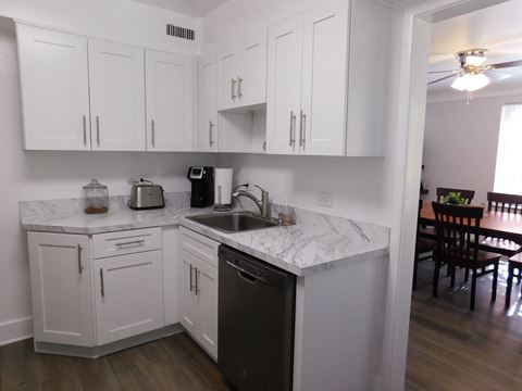 a kitchen with white cabinets and a sink and a table