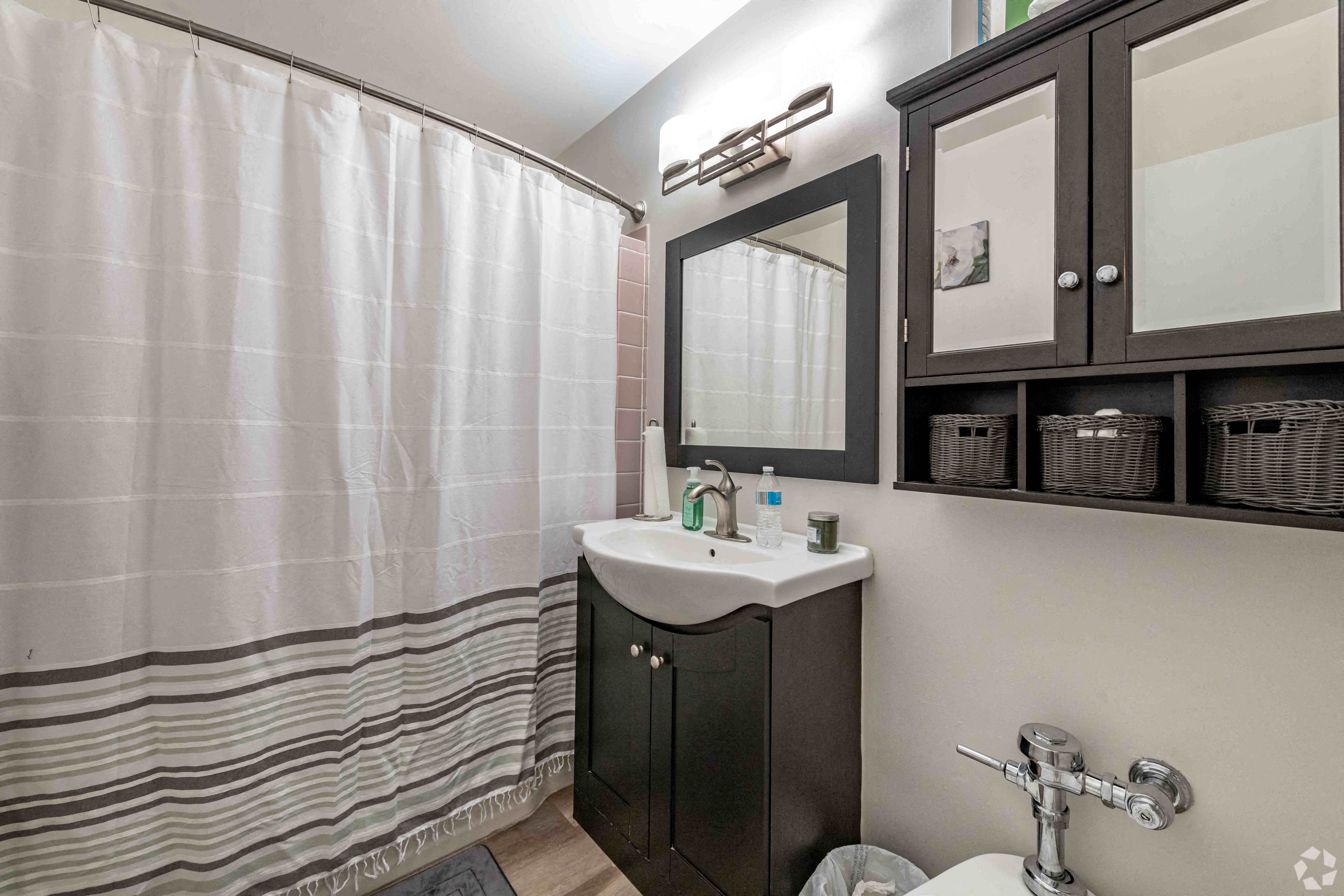 a bathroom with a shower and a sink and a mirror