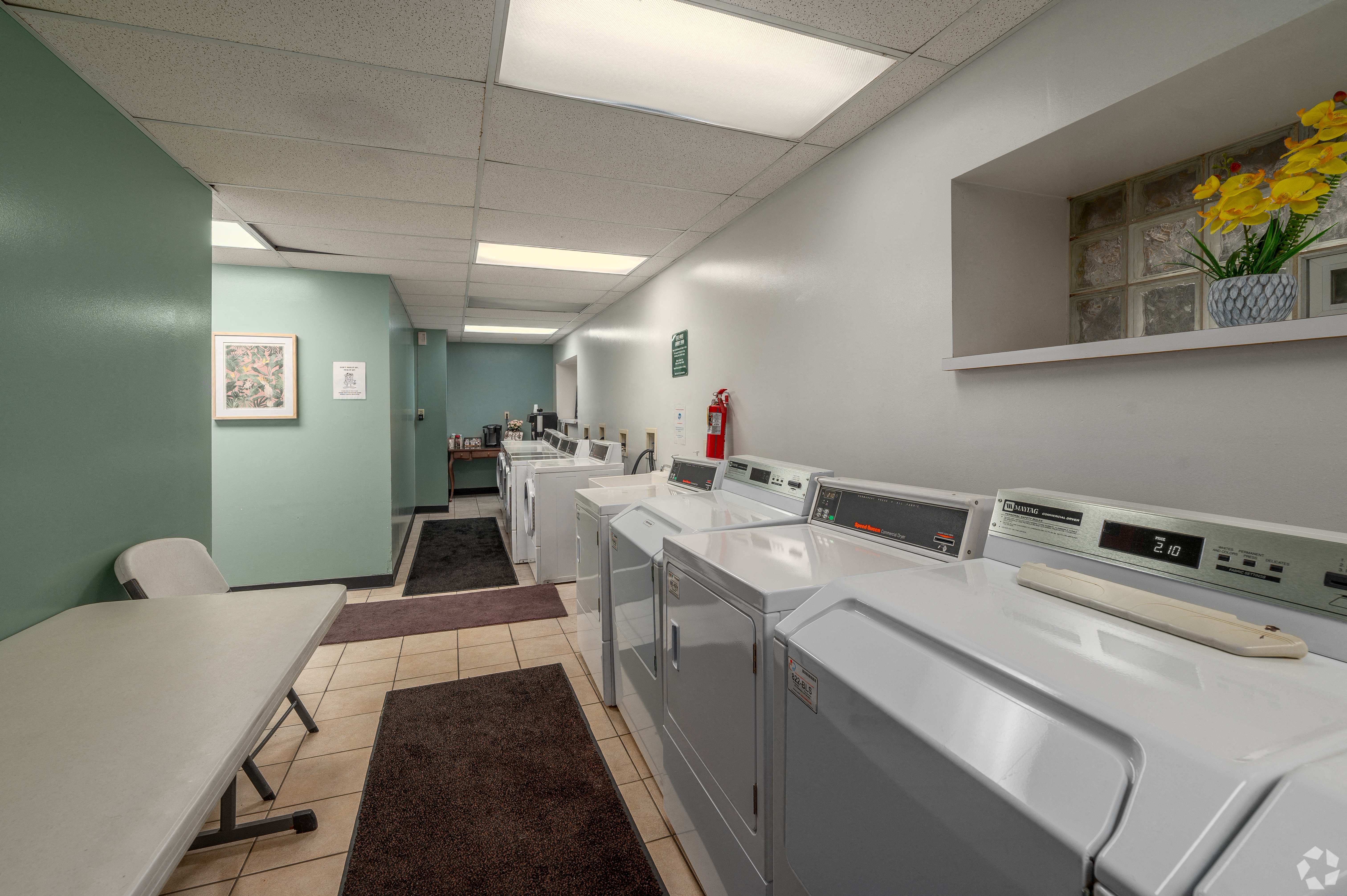 a laundry room with washers and dryers and a table with chairs