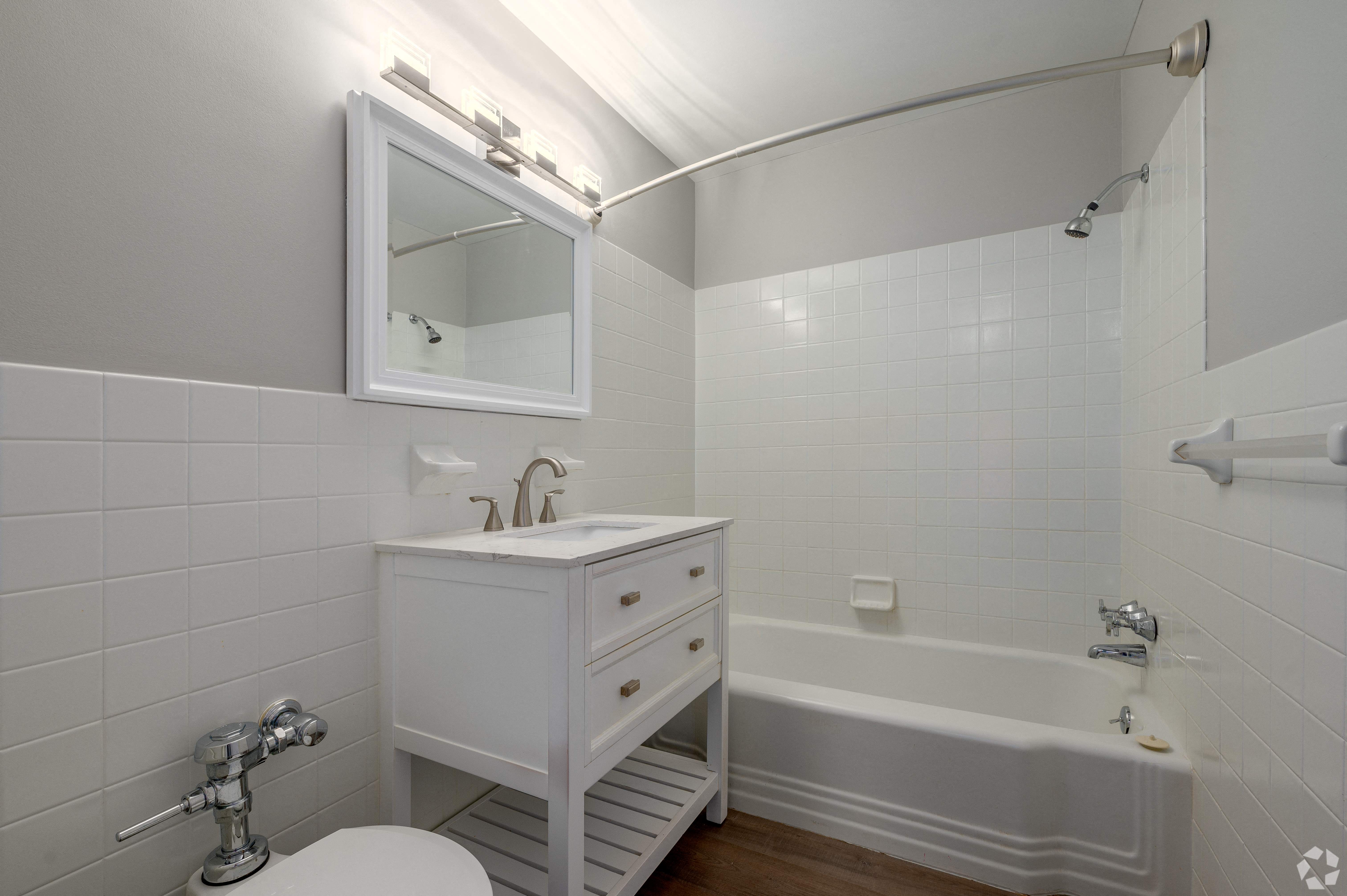 a white bathroom with a sink and a bath tub