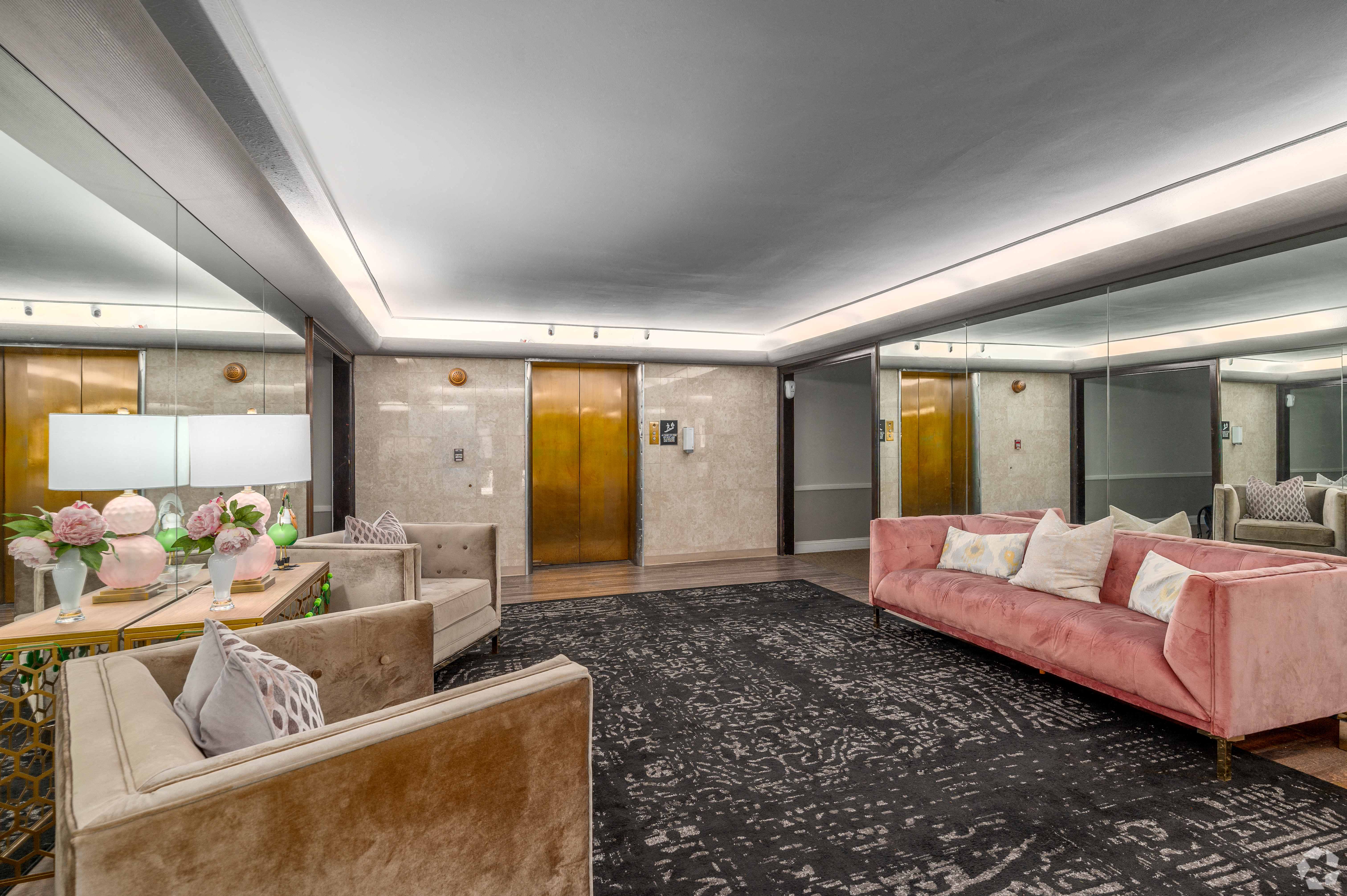 a living room with a pink couch and a rug