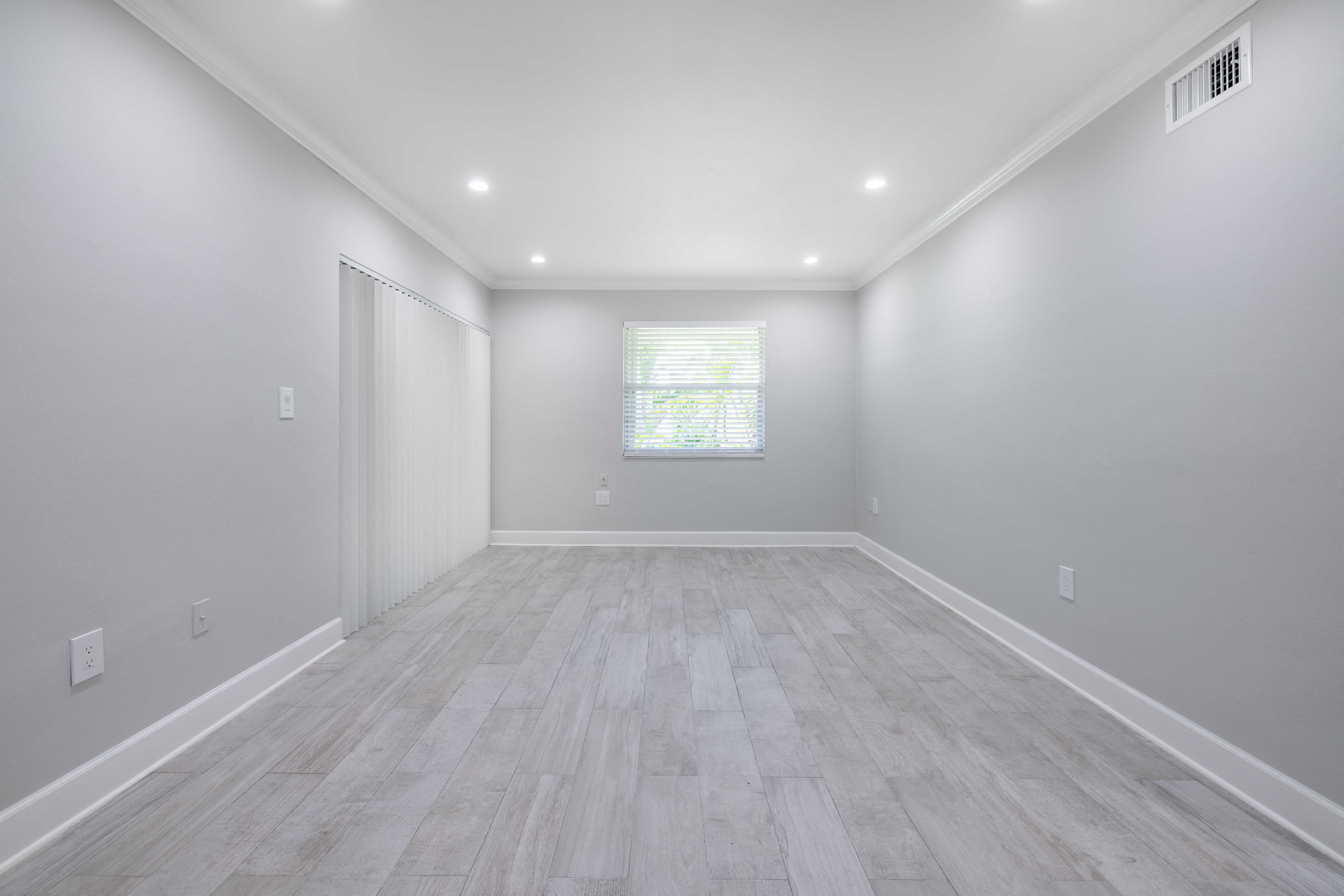the living room of a new home with white walls and wood flooring