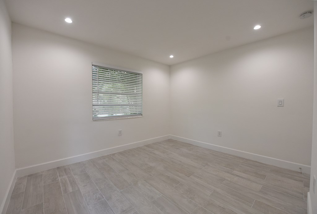 an empty room with white walls and a window