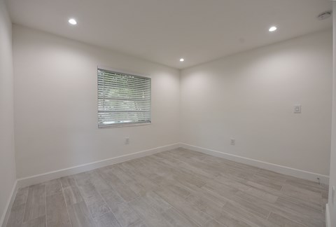 an empty room with white walls and a window