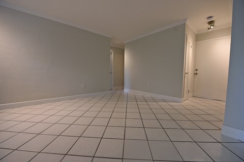 an empty living room with a white tiled floor