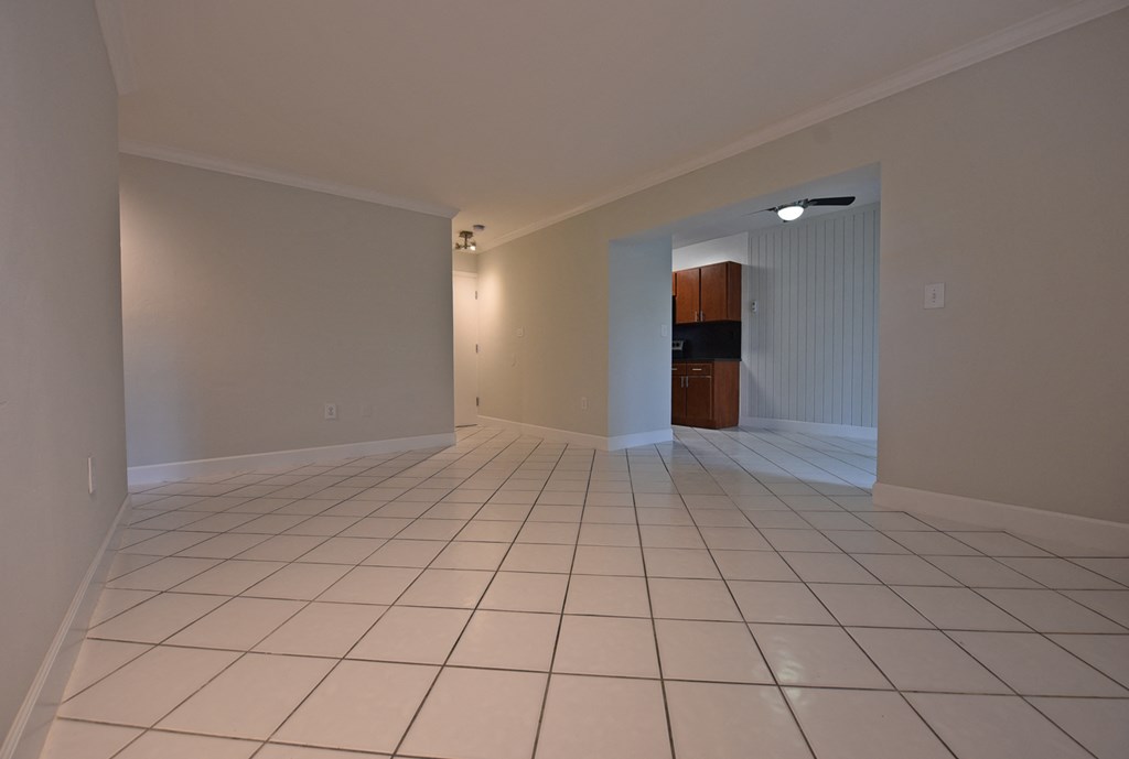 an empty living room with a tiled floor