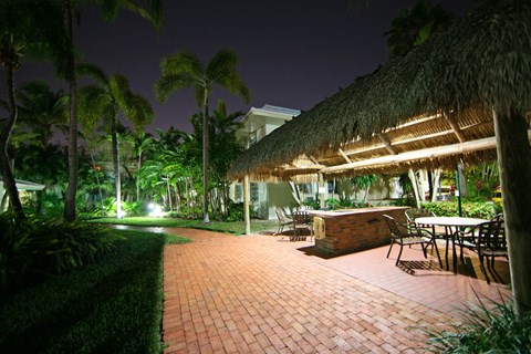 a patio with a bar and tables at night