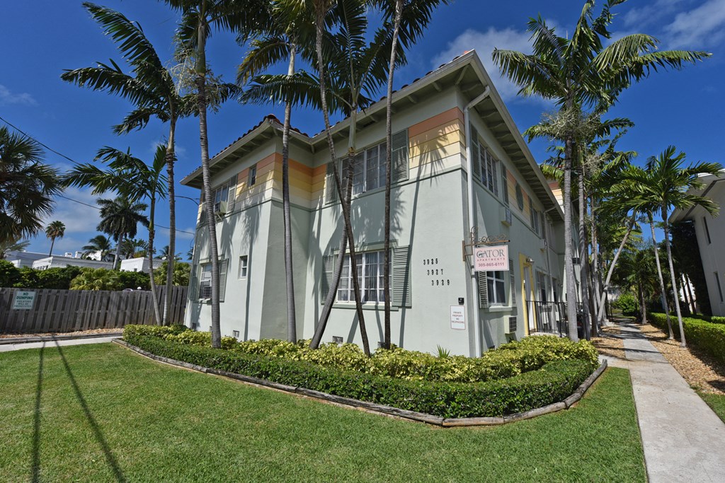 a small building with palm trees in front of it