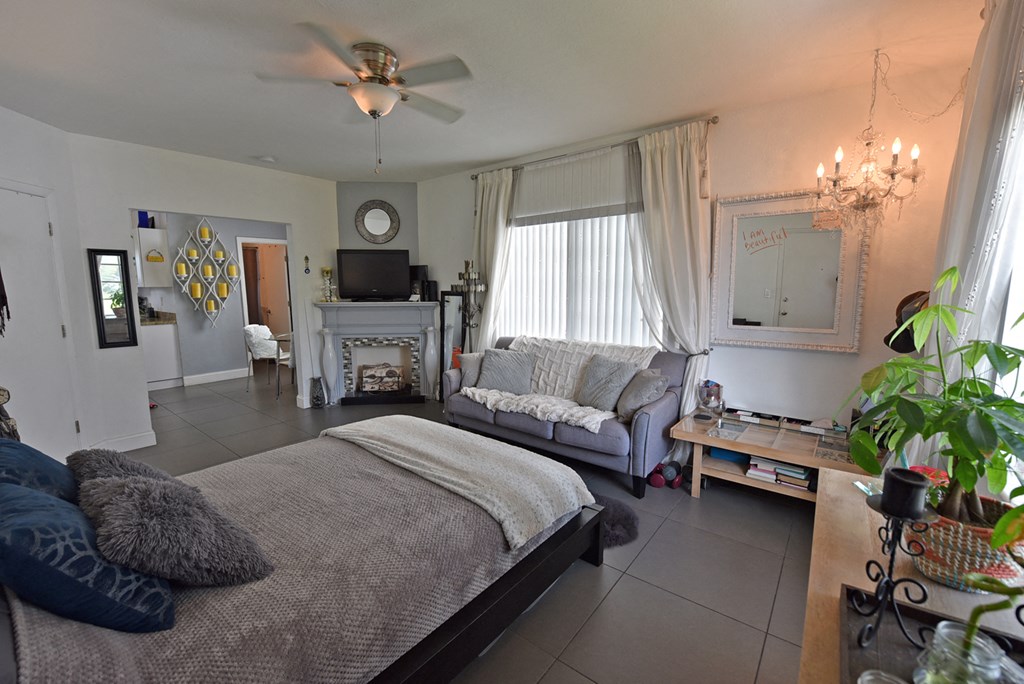 a bedroom with a bed and a living room with a fireplace