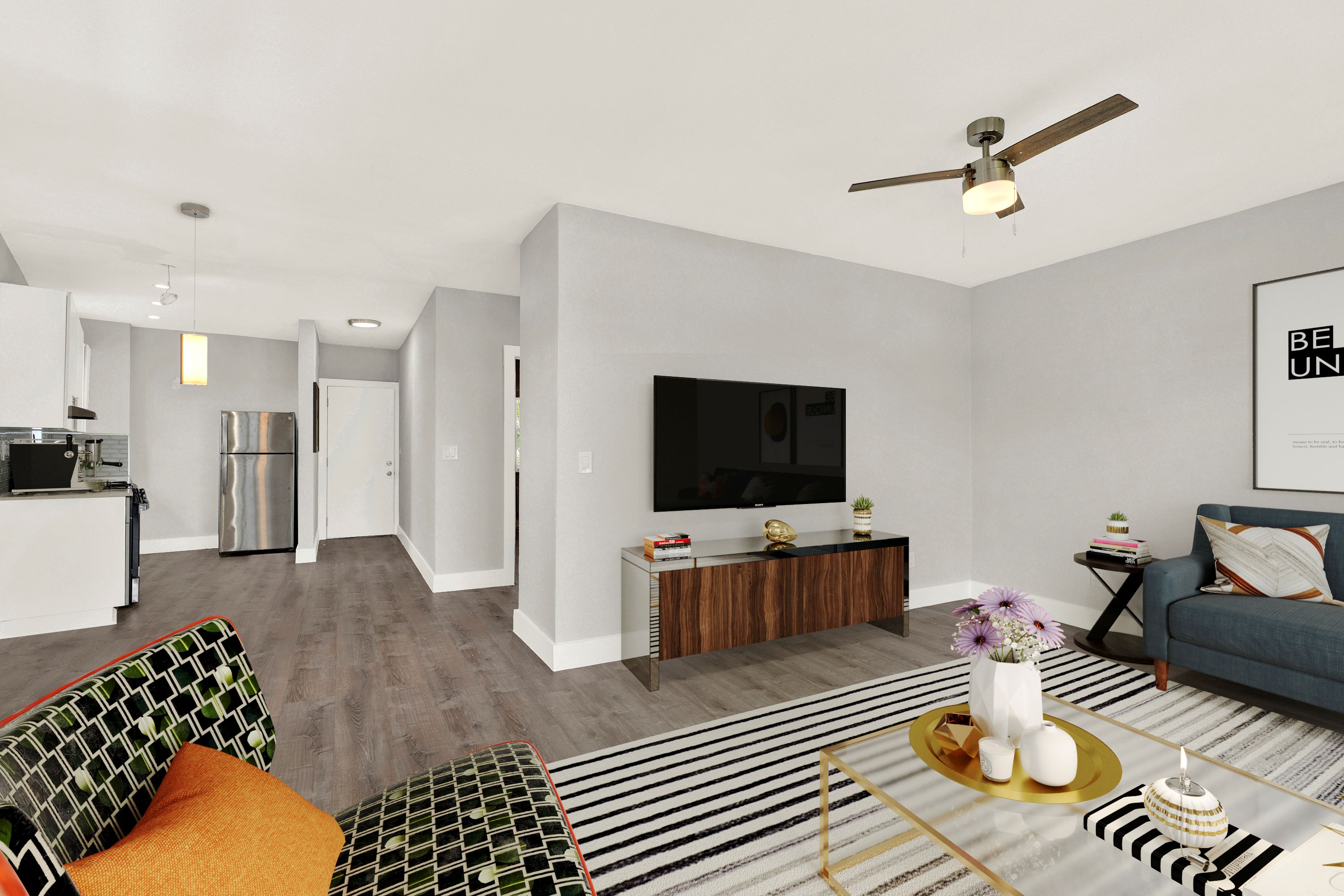 A living room with a black and white striped rug and a white vase on a coffee table.