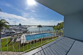 a balcony with a view of a swimming pool and boats in the water