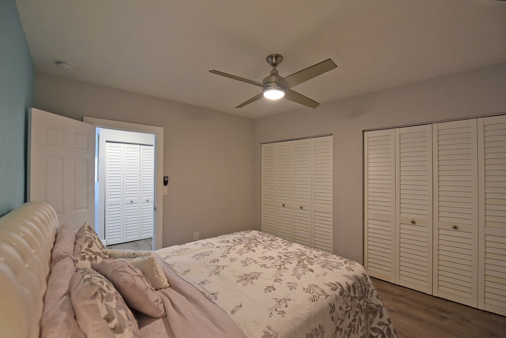 a bedroom with a large bed and a ceiling fan