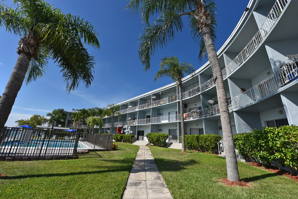 exterior view of the courtyard of a resort building with palm trees