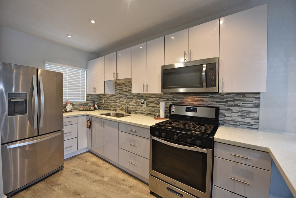 a kitchen with stainless steel appliances and white cabinets