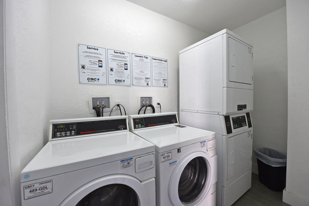 a laundry room with two washing machines and a refrigerator