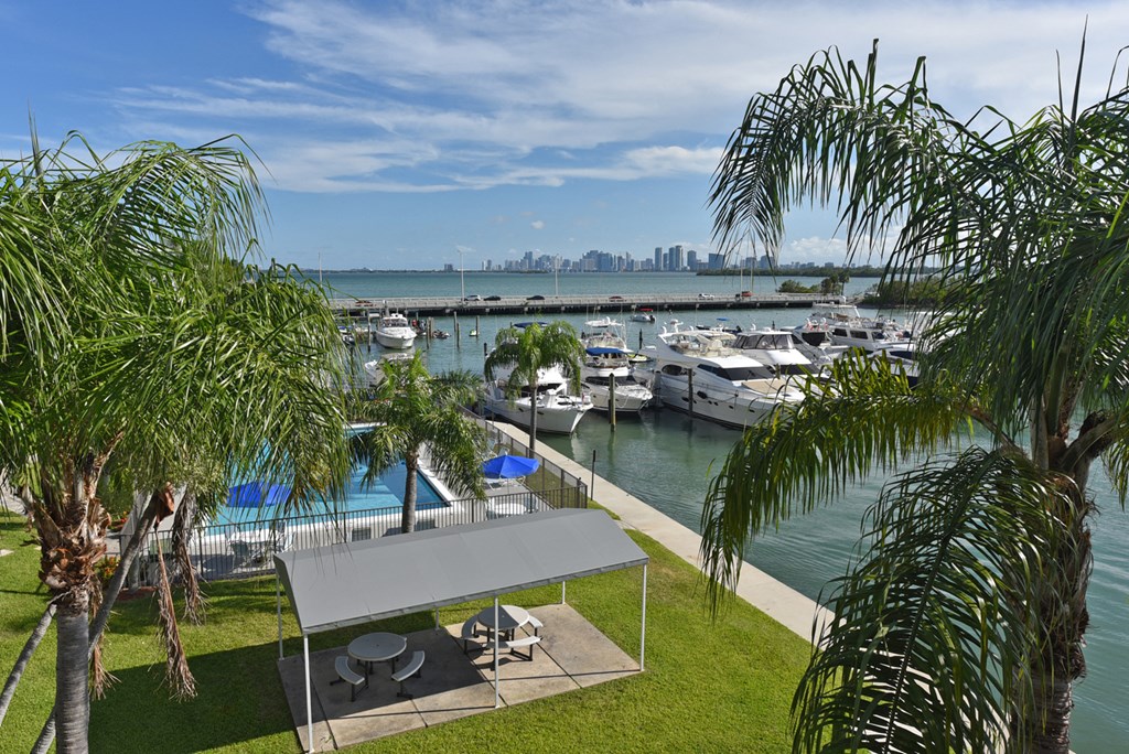 an aerial view of a marina with boats and a lawn and palm trees