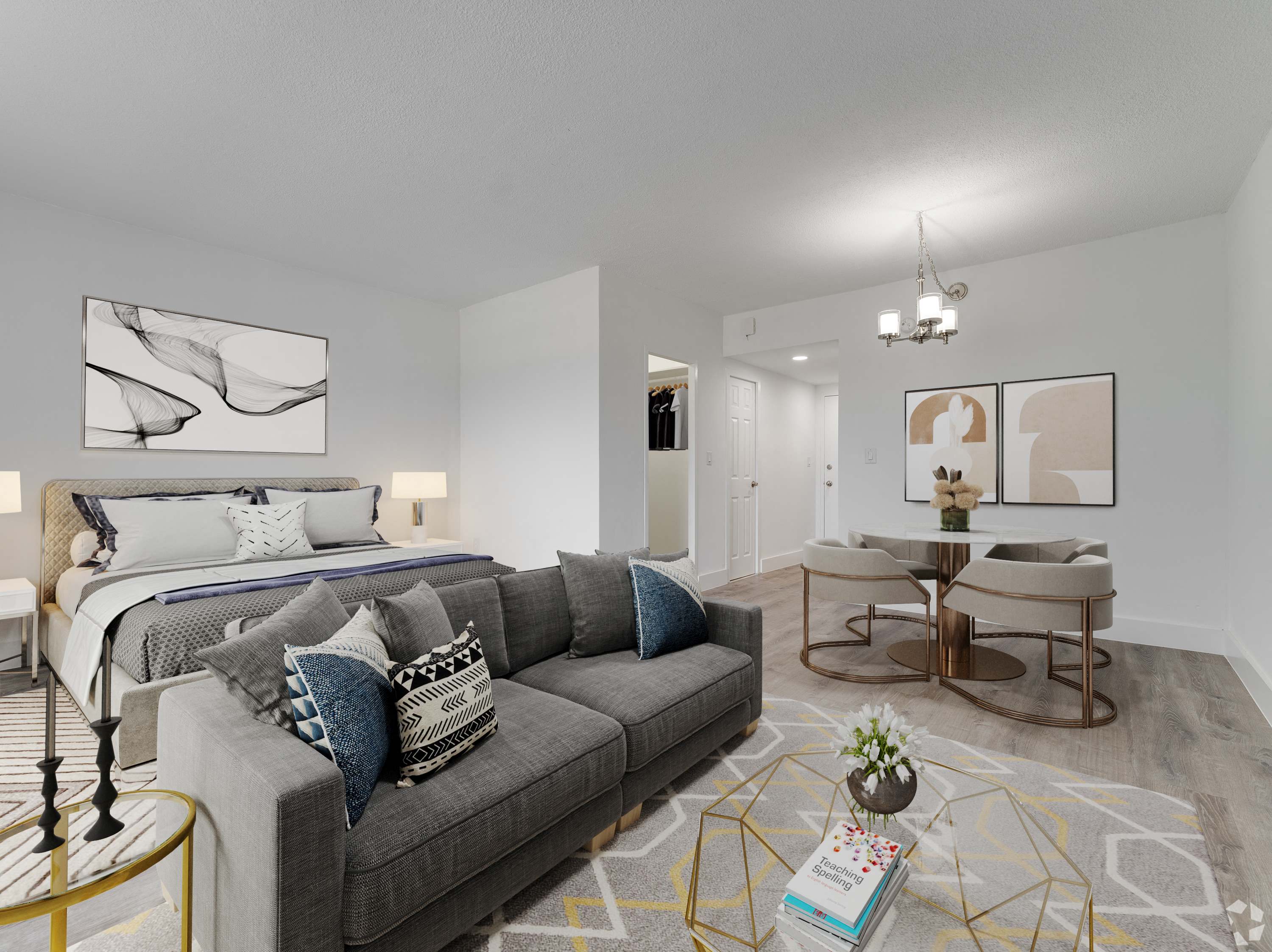 A modern living room with a grey couch and a gold side table.