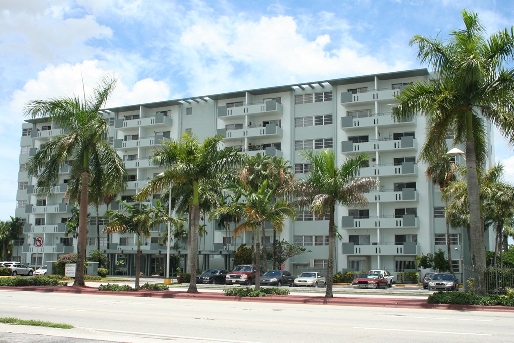 a large apartment building with palm trees in front of it