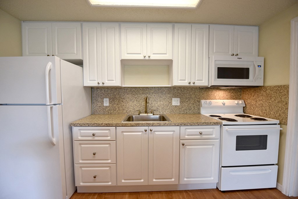 a kitchen with white appliances and white cabinets