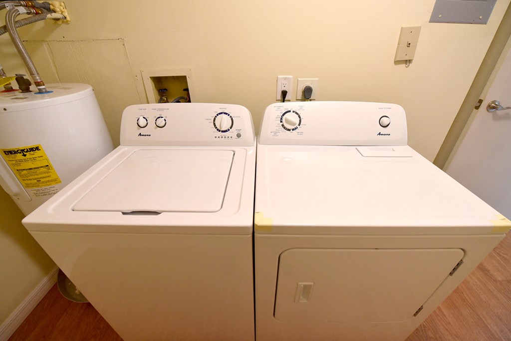 two washers and a dryer in a laundry room