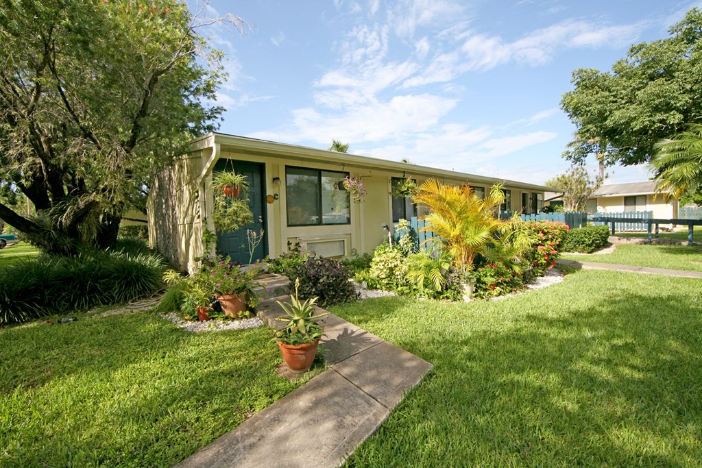 a house with a lawn and potted plants in front of it