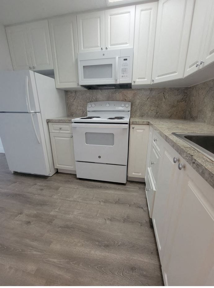 a kitchen with white appliances and white cabinets
