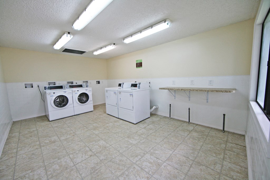 an empty laundry room with washing machines and dryers