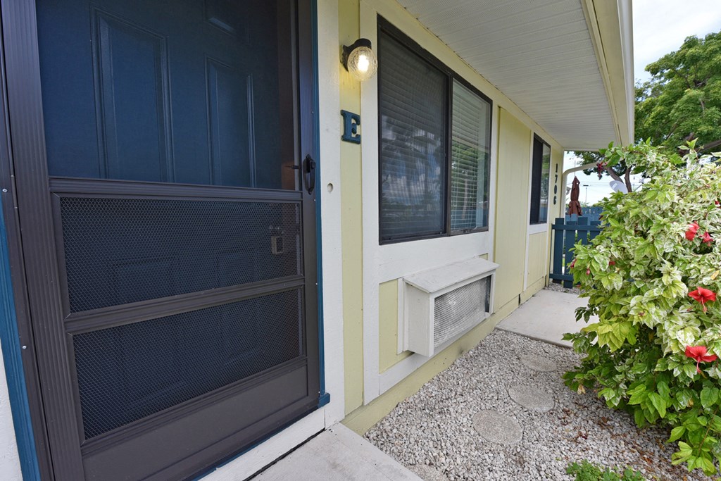 the front porch of a house with a black door