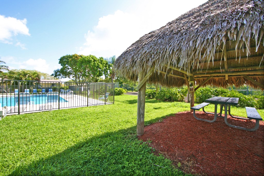 a pavilion with a picnic table next to a pool
