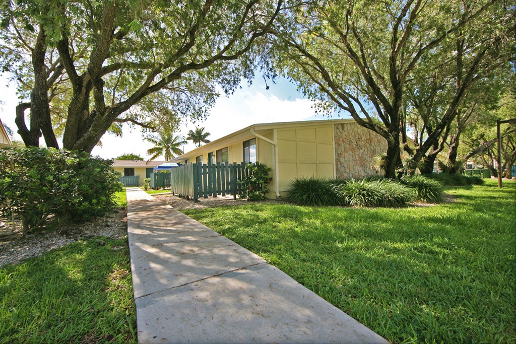 a sidewalk in front of a yellow house