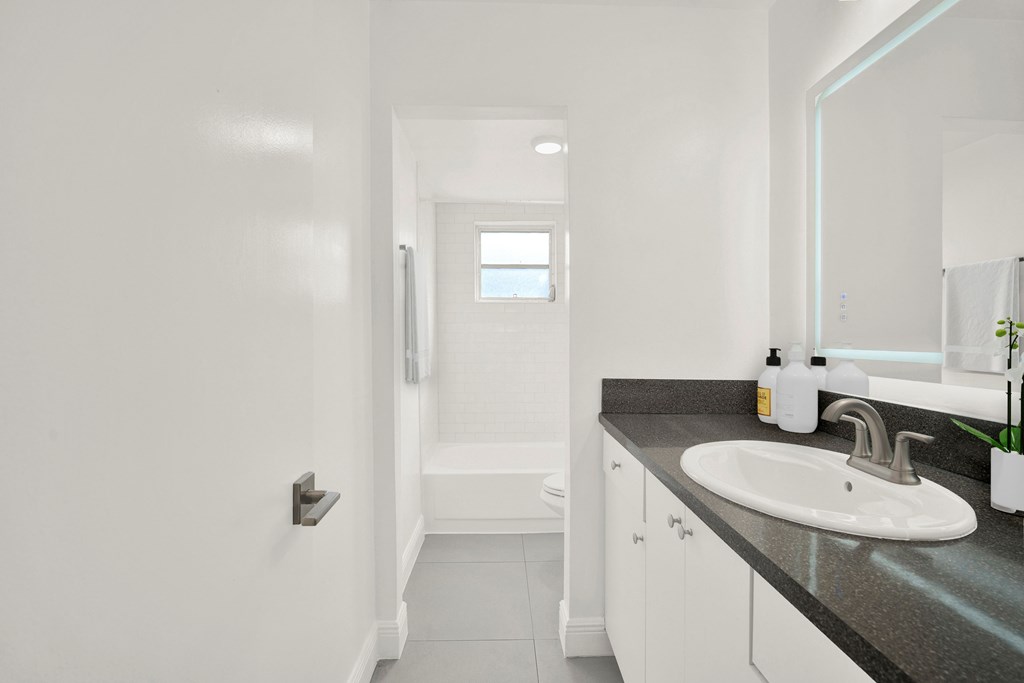 A bathroom with a sink, mirror, and toilet.