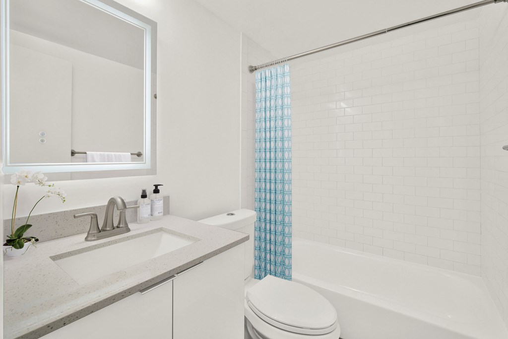 A white bathroom with a sink, toilet, and bathtub.