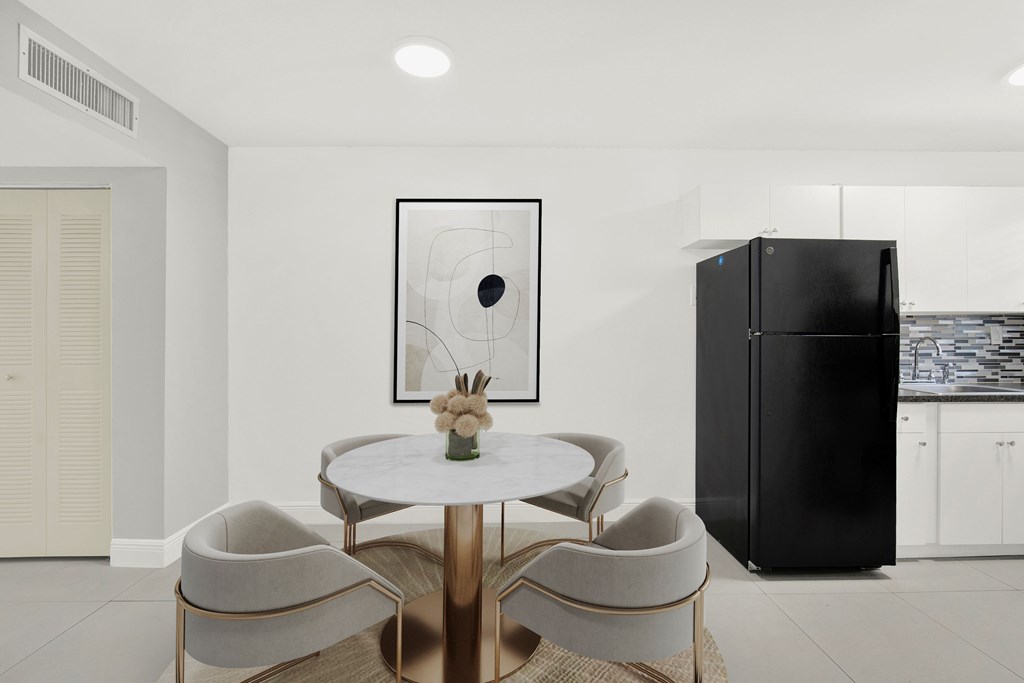 A modern dining room with a round table and chairs.