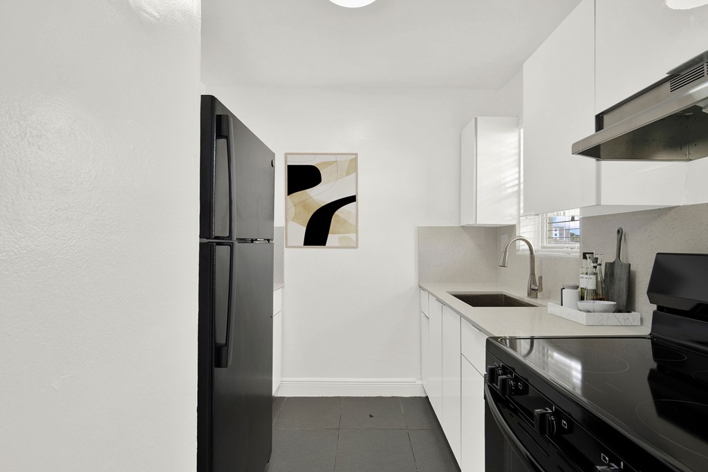 A modern kitchen with a black refrigerator and stove.