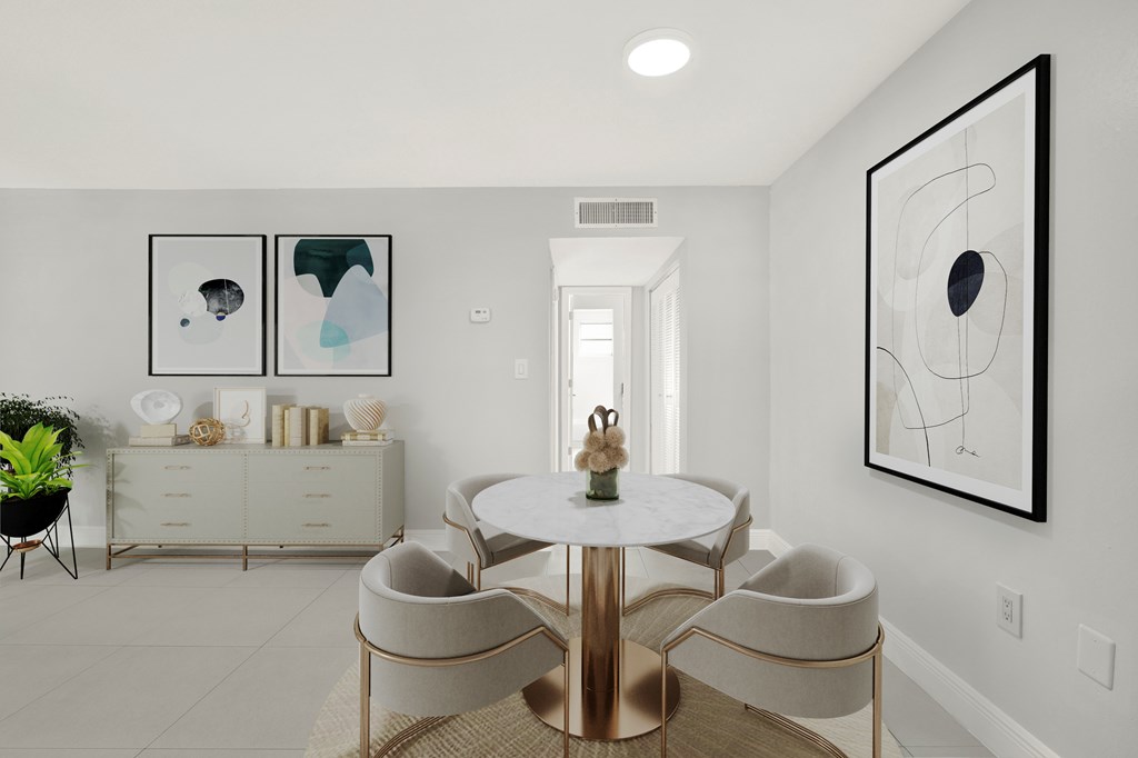 A dining room with a white table and chairs.