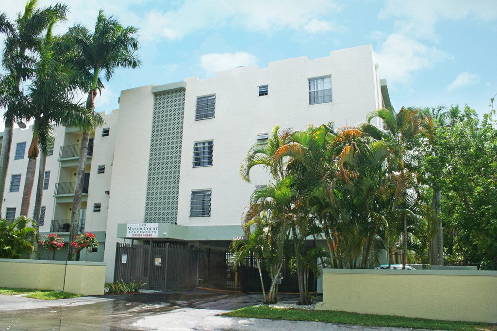 a white building with palm trees in front of it