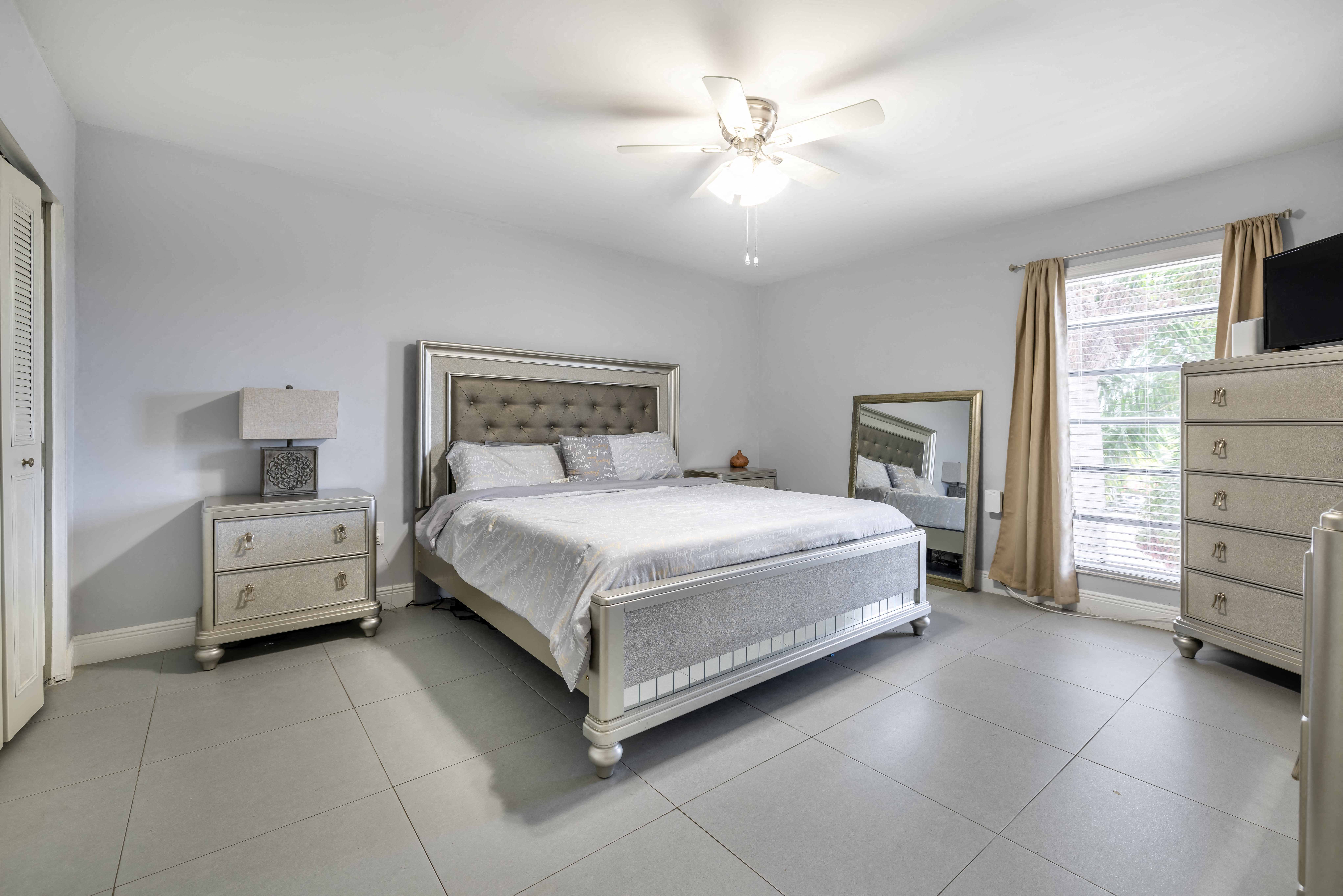 a white bedroom with a bed and a ceiling fan