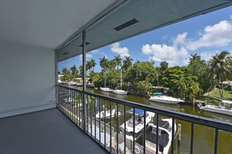 a balcony overlooking a marina with boats and palm trees