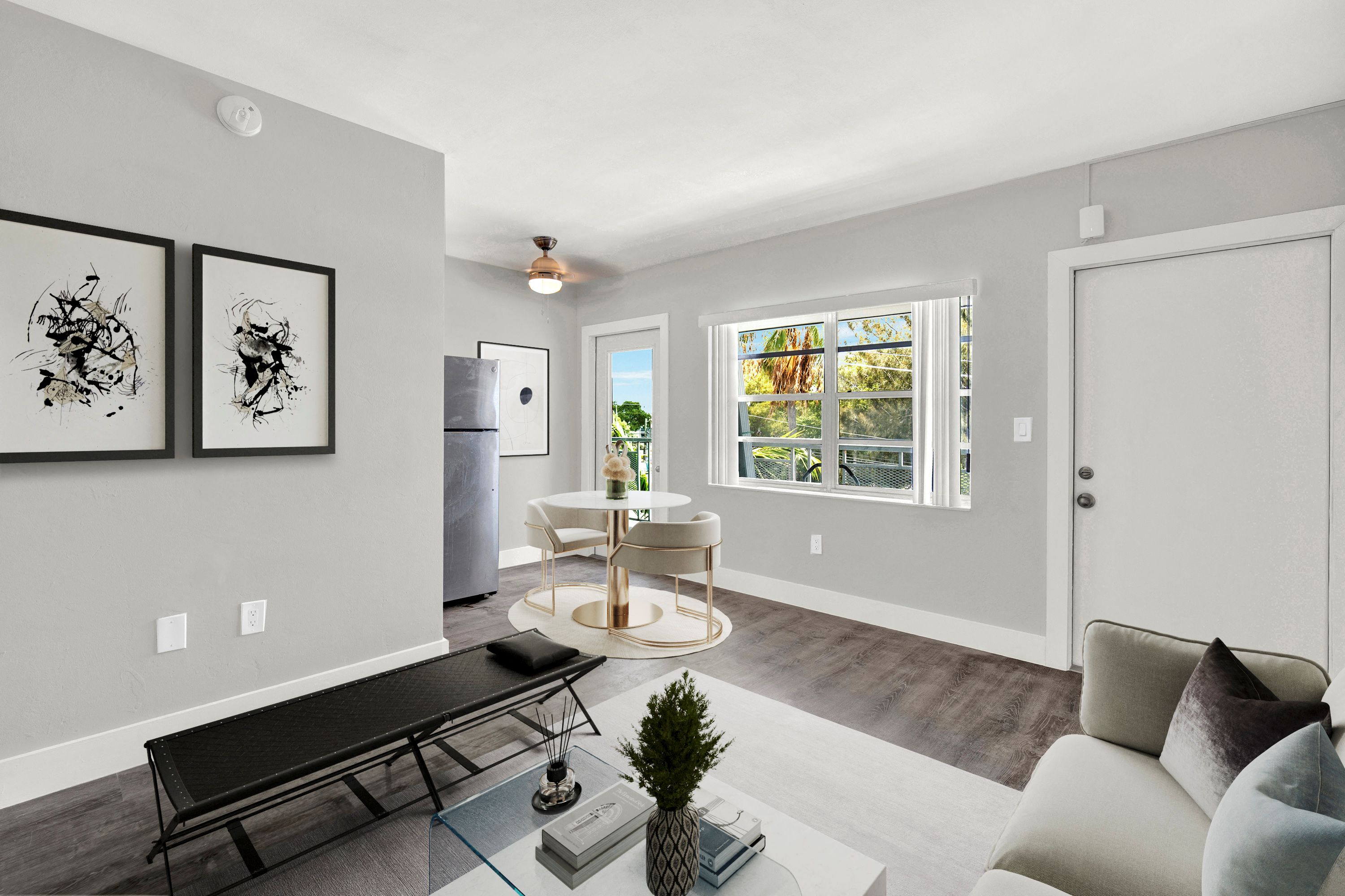 A modern living room with a black sofa and a glass coffee table.