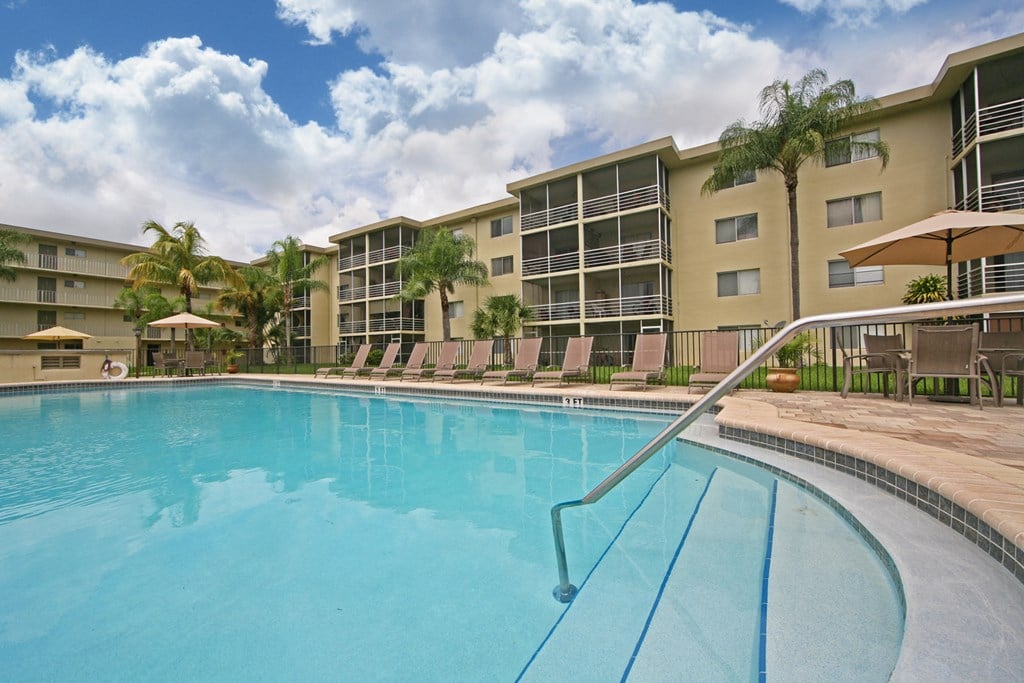 a large swimming pool in front of an apartment building
