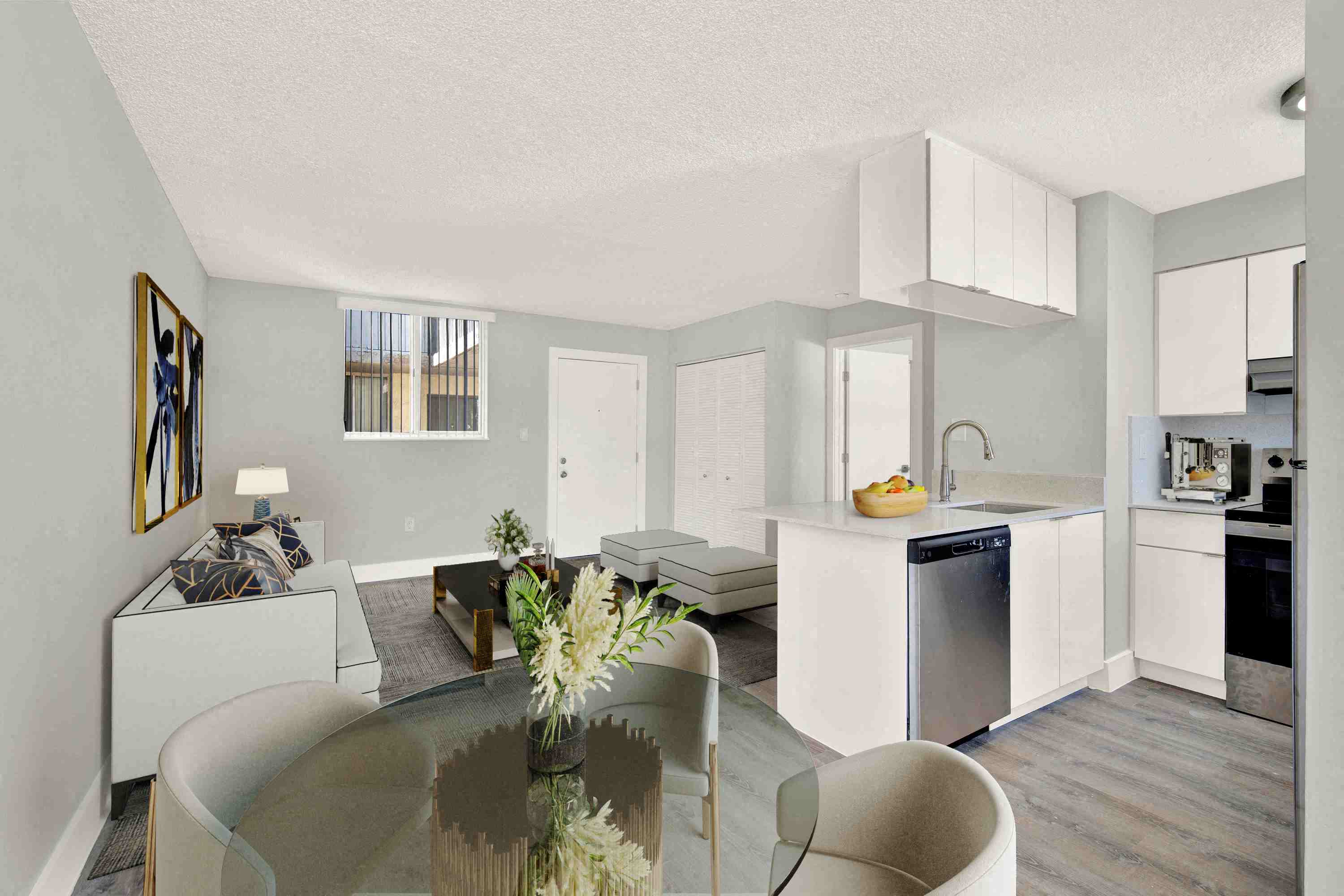 A modern kitchen with a glass table and white cabinets.
