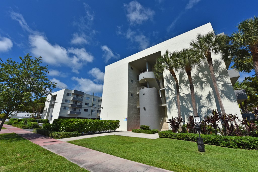 a large white building with palm trees in front of it