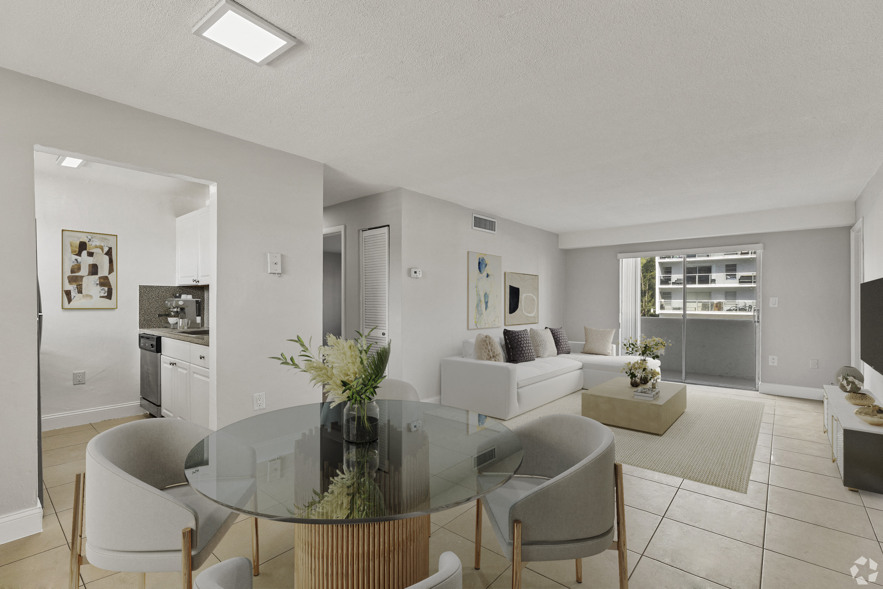 A modern dining room with a glass table and chairs.