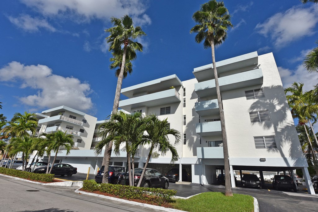 a large white building with palm trees in front of it