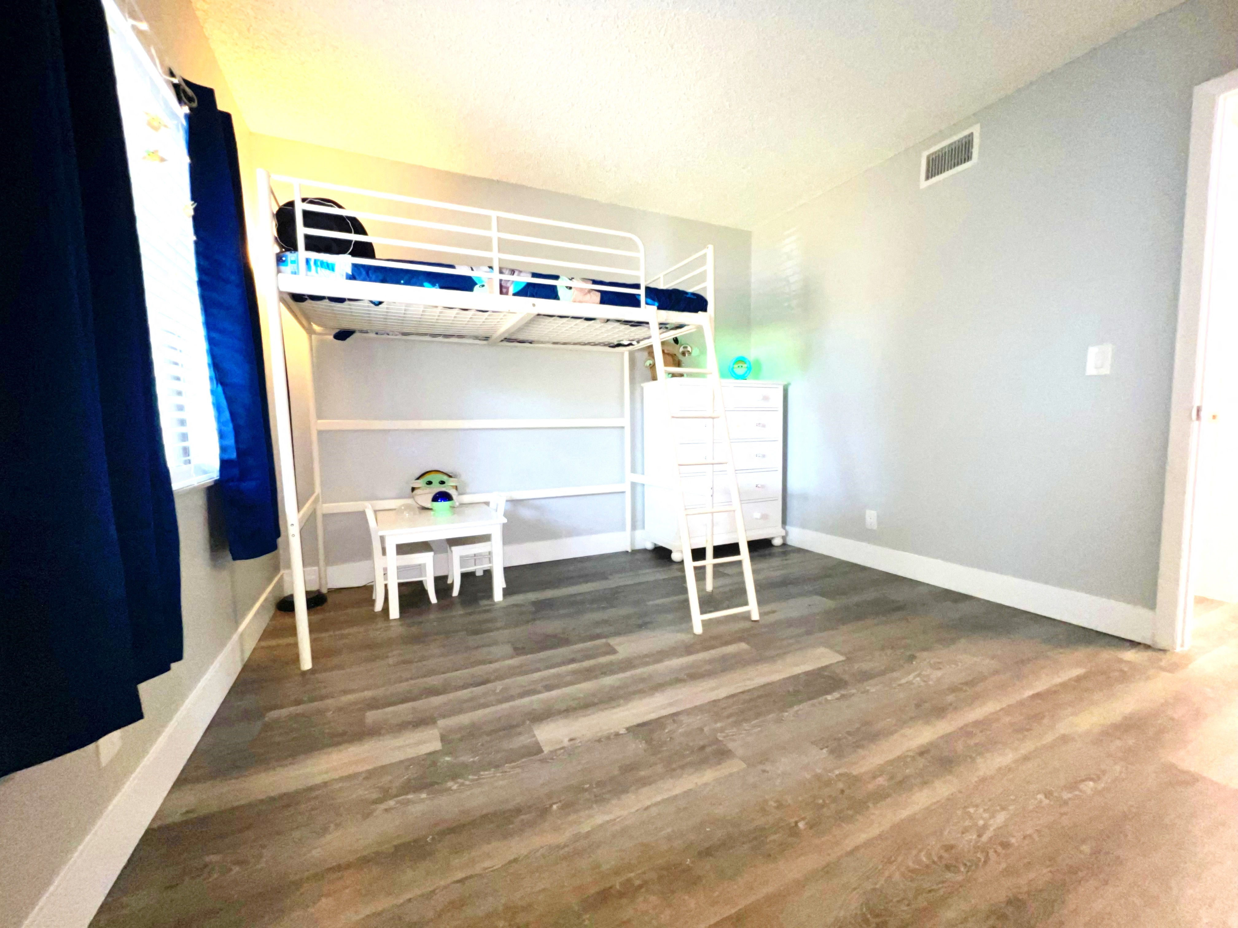 a bunk bed in a room with a wooden floor
