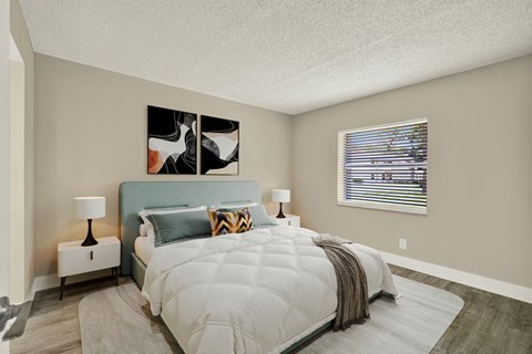 A bedroom with a large bed and a painting on the wall.